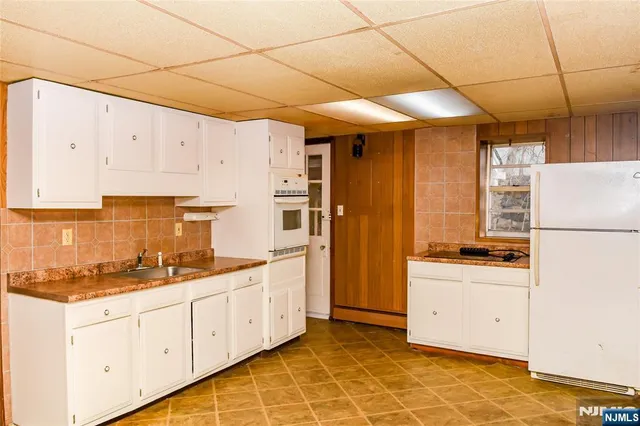 a kitchen with granite countertop a sink a stove and refrigerator