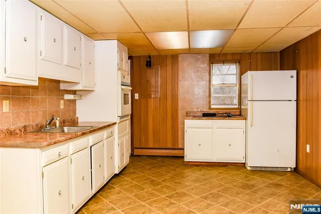a kitchen with white cabinets and white appliances