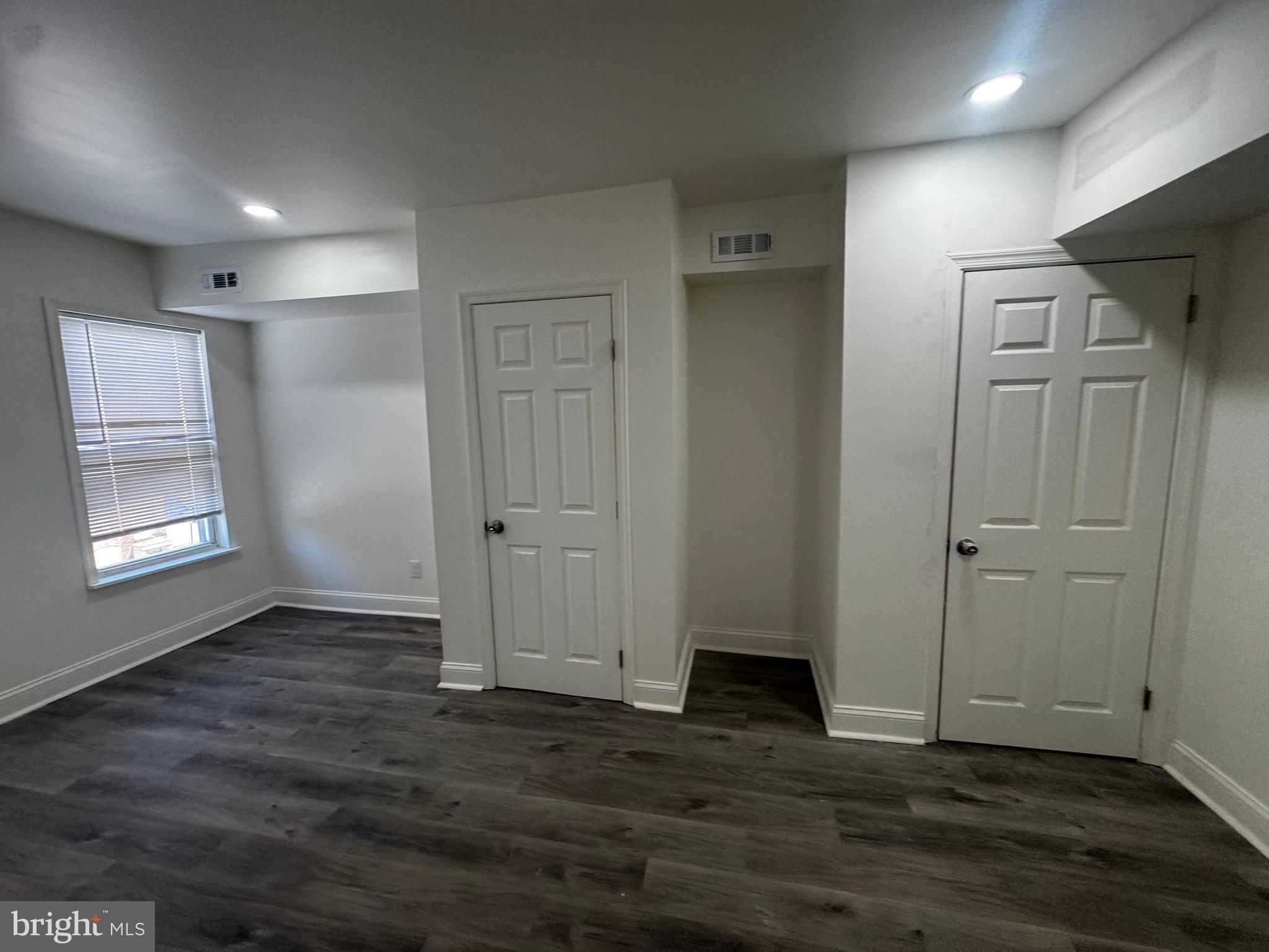 1527 Riggs Avenue Baltimore, MD 21217 - Photo 11 of 16 an empty room with wooden floor and windows