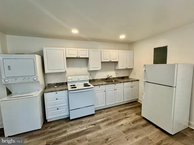 a kitchen with a refrigerator sink stove and cabinets
