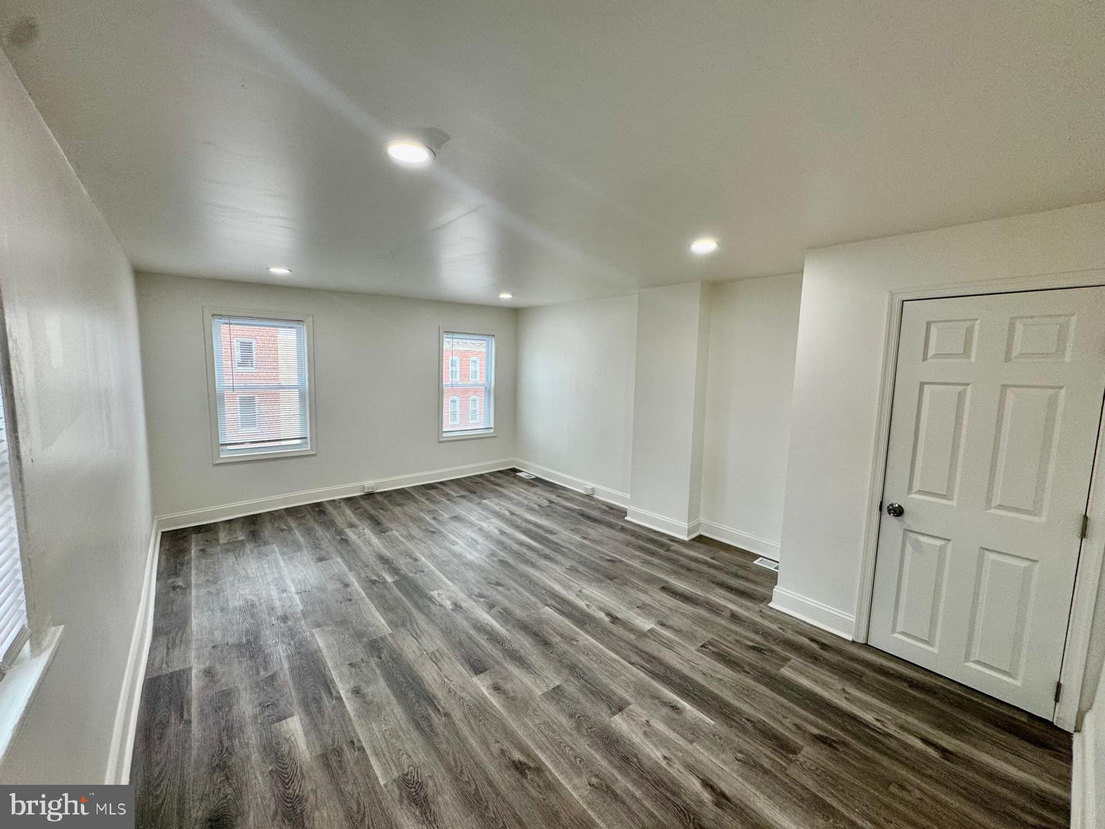 1527 Riggs Avenue Baltimore, MD 21217 - Photo 3 of 16 an empty room with wooden floor and windows