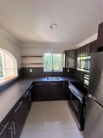 a kitchen with granite countertop a refrigerator and stove
