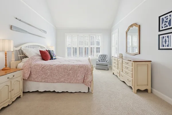 a bedroom with a bed a mirror and a dresser