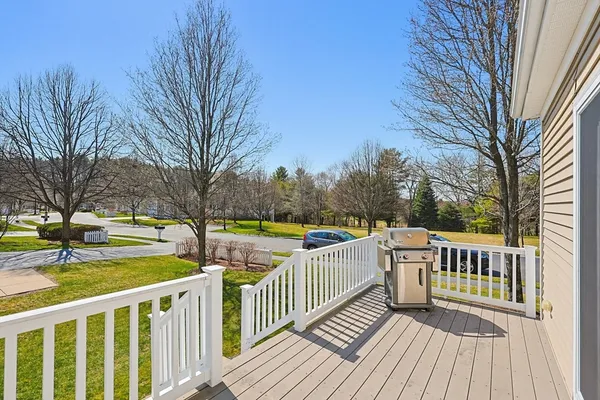 a view of a wooden deck and trees with wooden fence and floor
