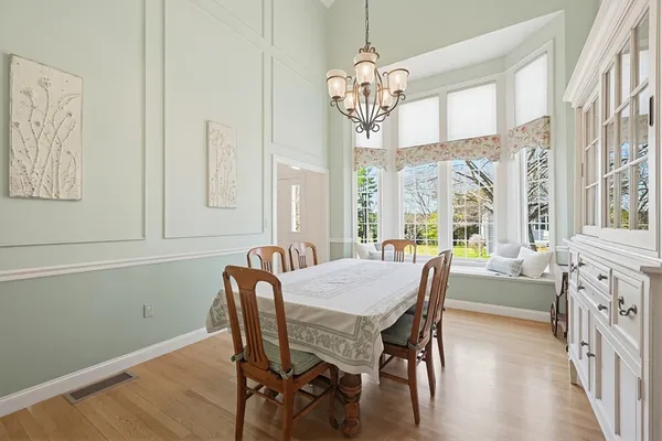 a view of a dining room with furniture a chandelier and wooden floor
