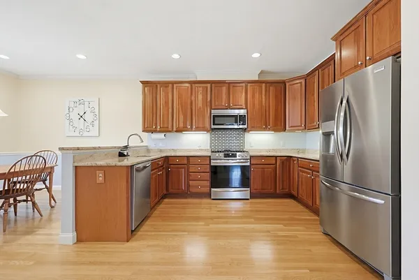 a kitchen with stainless steel appliances granite countertop a refrigerator stove top oven and sink
