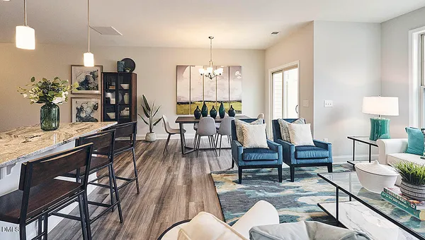 a kitchen with stainless steel appliances kitchen island granite countertop a dining table chairs and white cabinets