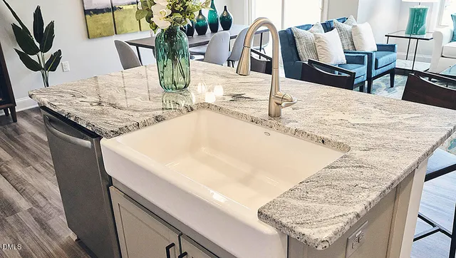 a kitchen with stainless steel appliances granite countertop a sink a stove and a wooden floor