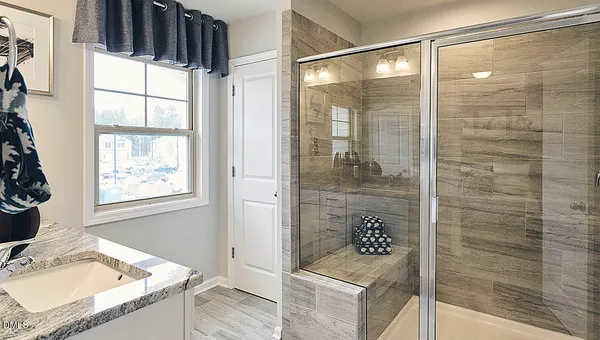 a bathroom with a double vanity sink a mirror and shower