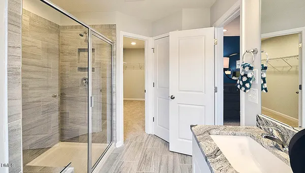 a bathroom with a granite countertop sink mirror and shower