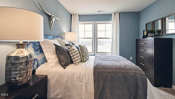 a bedroom with a bed and a large window