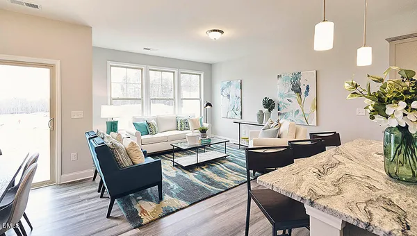 a living room with furniture a potted plant and a table