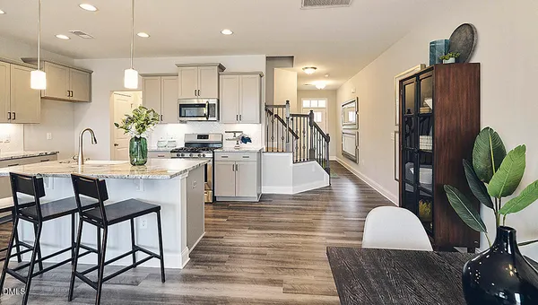 a kitchen with granite countertop a sink appliances cabinets and furniture