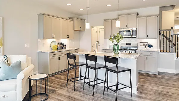 a kitchen with stainless steel appliances granite countertop a stove refrigerator a sink dishwasher a dining table and chairs with wooden floor