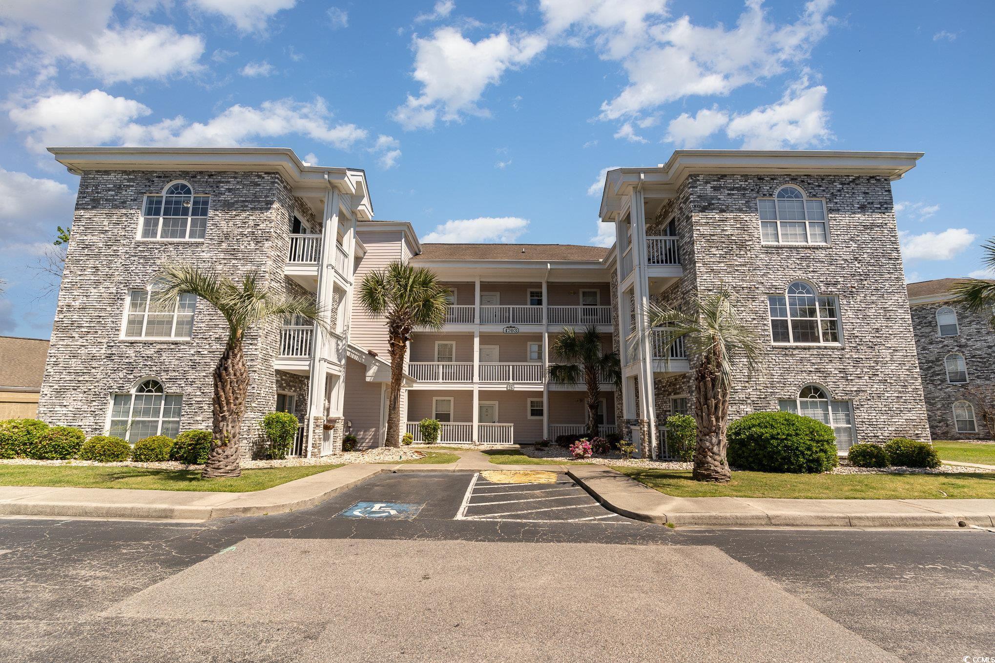 4703 Wild Iris Drive, Unit 301 Myrtle Beach, SC 29577 - Photo 1 of 25 View of building exterior with uncovered parking