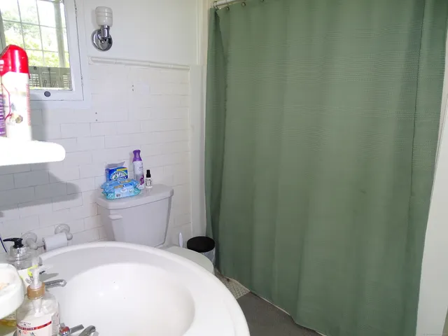 a white toilet sitting next to a white sink and vanity