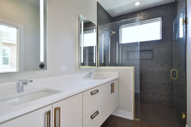 a spacious bathroom with a double vanity sink a mirror and a shower