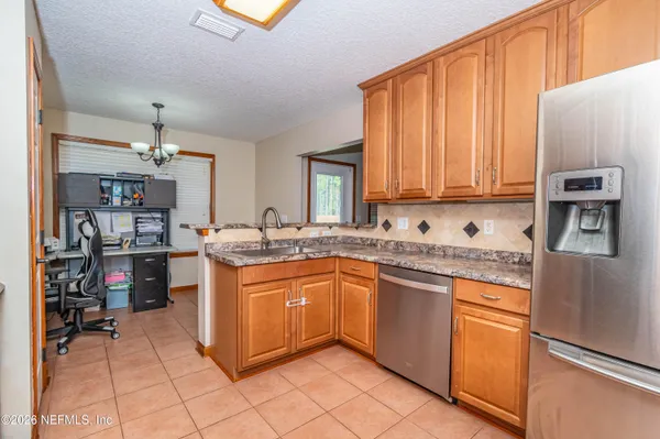a kitchen with stainless steel appliances granite countertop a refrigerator and a stove top oven