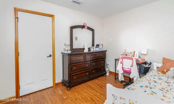 a room with a baby bed and dresser