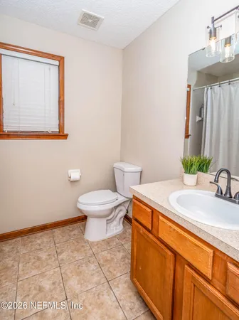 a bathroom with a sink a toilet and mirror