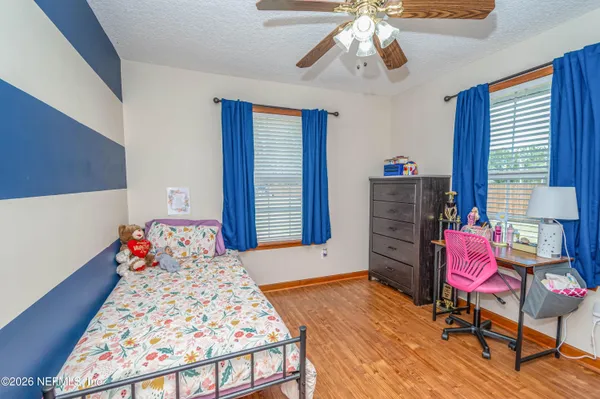 a bedroom with a bed and wooden floor