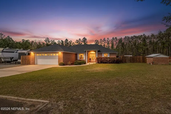 a front view of a house with a garden and yard