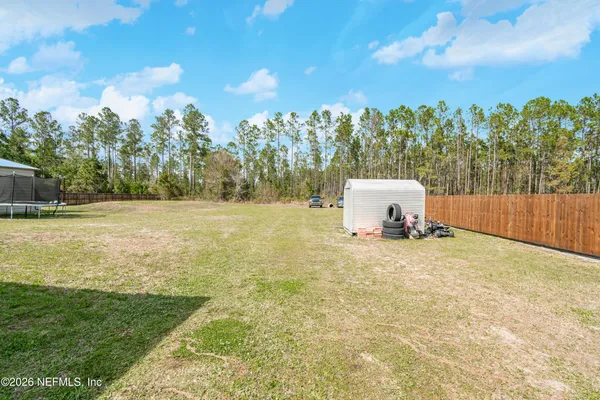 a view of a field with trees in the background
