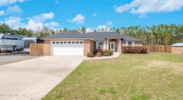 a front view of a house with a yard and potted plants