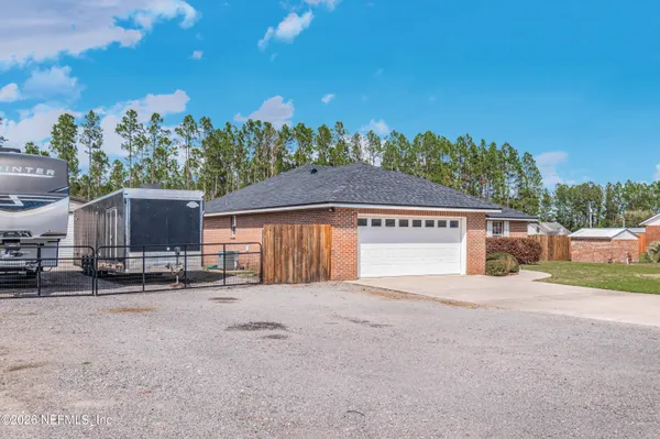 a view of a house with a yard and large tree