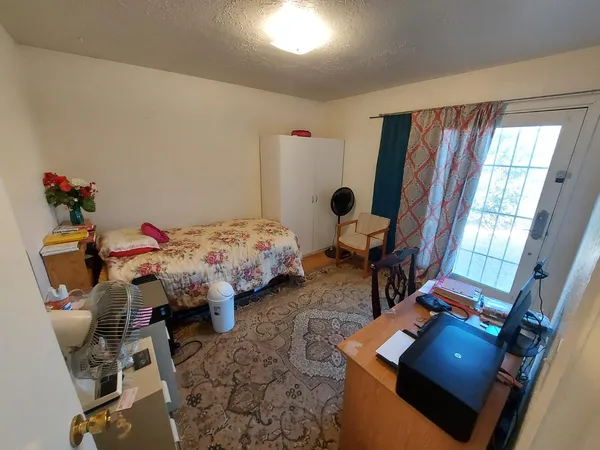 a bedroom with a bed chair and window