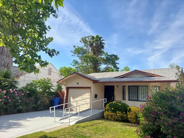 a front view of a house with a yard and potted plants
