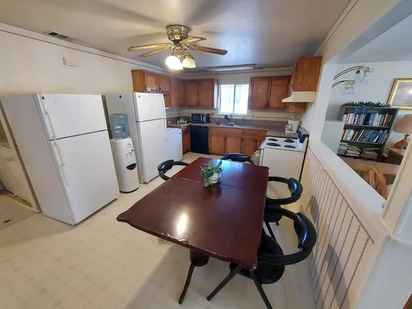 a living room with furniture and a refrigerator