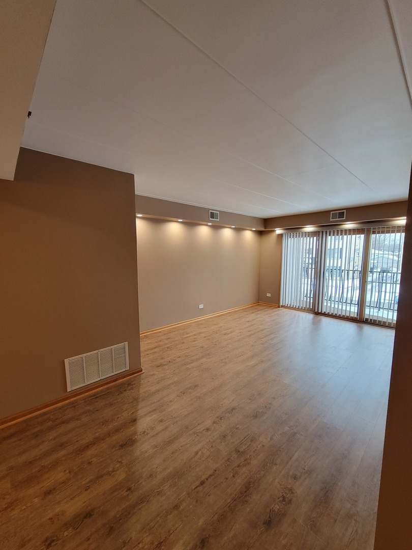 10418 South Keating Avenue, Unit 1A Oak Lawn, IL 60453 - Photo 3 of 15 an empty room with wooden floor and windows
