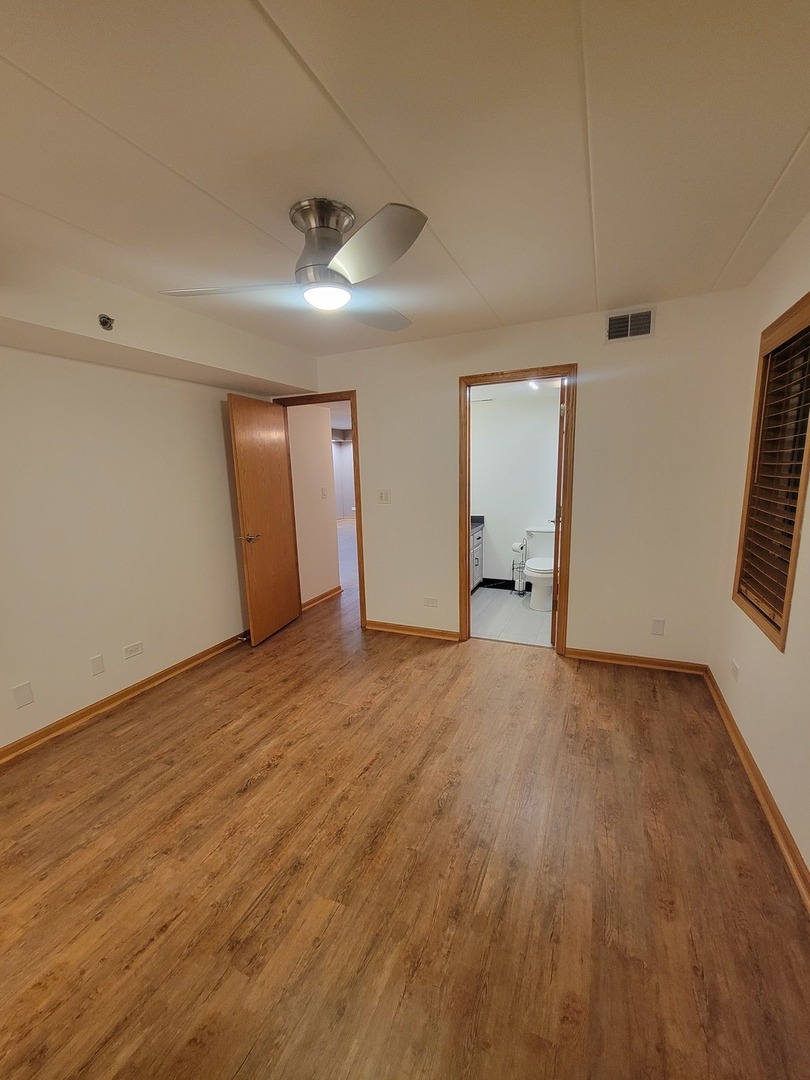 10418 South Keating Avenue, Unit 1A Oak Lawn, IL 60453 - Photo 7 of 15 an empty room with wooden floor and windows