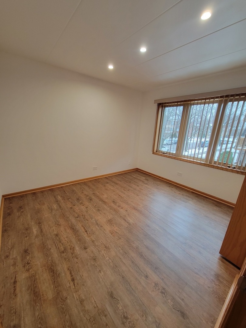 10418 South Keating Avenue, Unit 1A Oak Lawn, IL 60453 - Photo 8 of 15 an empty room with wooden floor and windows