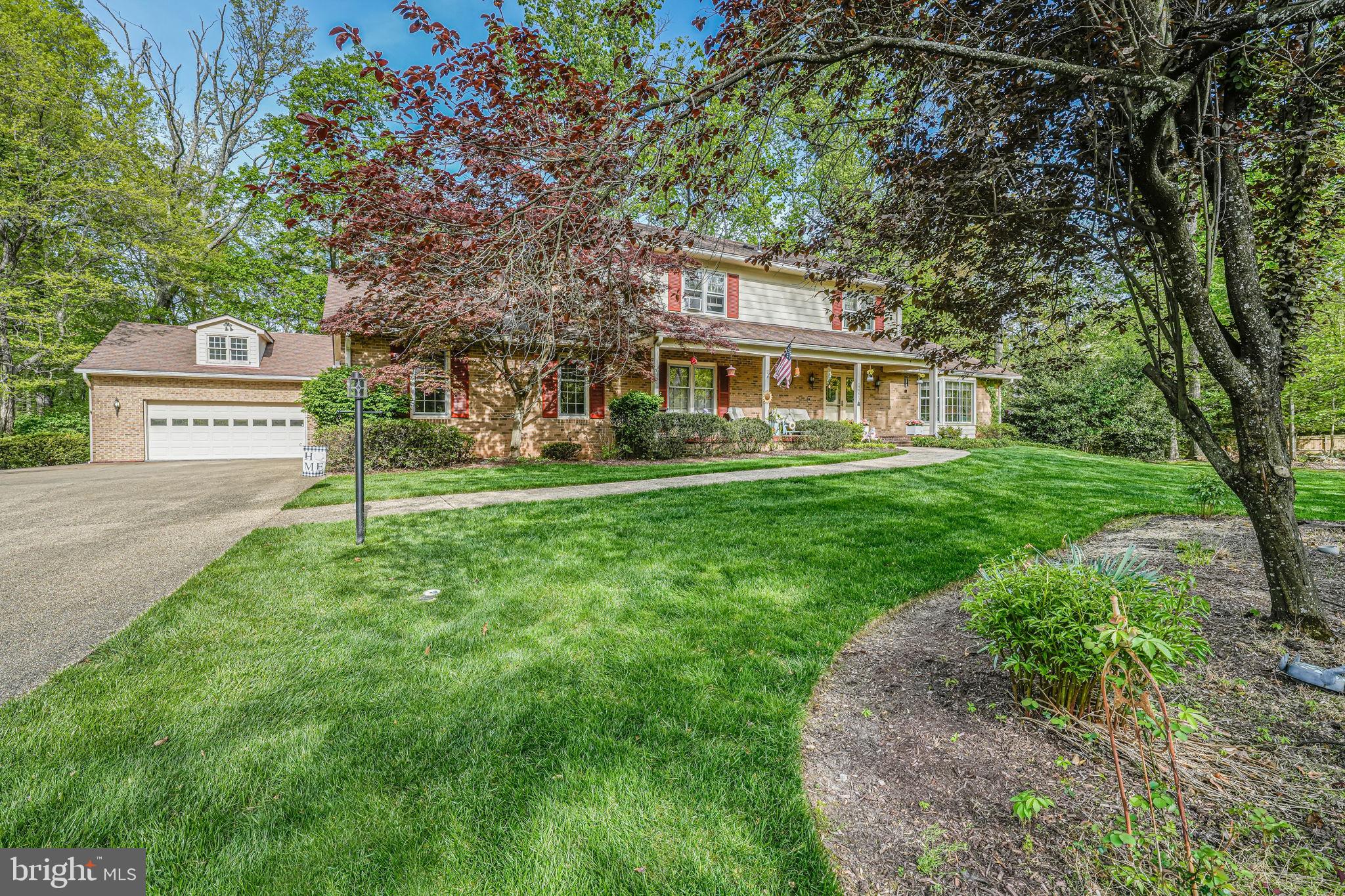 12003 Turf Lane Reston, VA 20191 - Photo 3 of 14 a front view of a house with a garden and trees