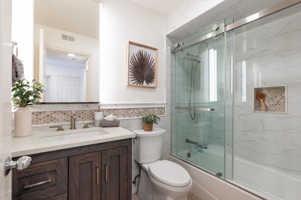 400 The Strand North, Unit 27 Oceanside, CA 92054 - Photo 12 of 25 a bathroom with a sink a toilet and shower