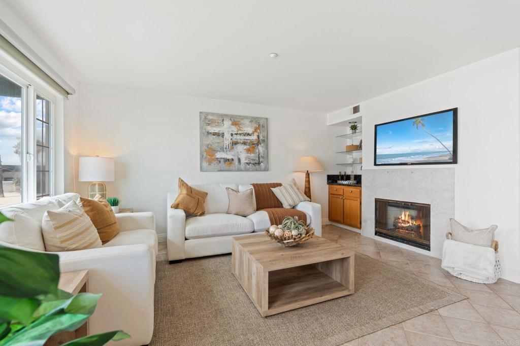 400 The Strand North, Unit 27 Oceanside, CA 92054 - Photo 7 of 25 a living room with furniture a fireplace and a flat screen tv