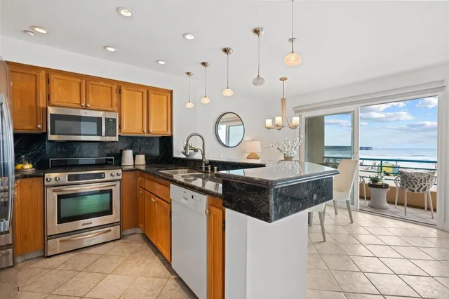 a kitchen with stainless steel appliances granite countertop a stove a sink and a microwave