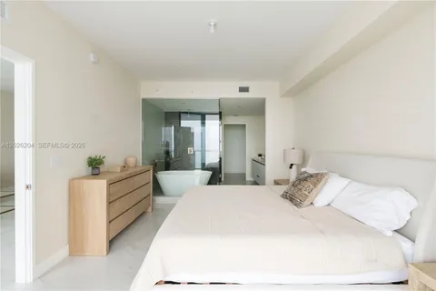 a bedroom with a bed and a view of living room