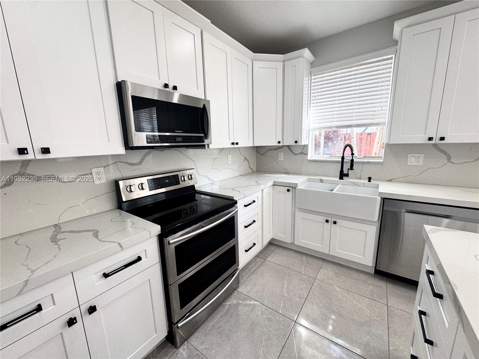 12283 Southwest 123rd Terrace Miami, FL 33186 - Photo 13 of 46 a kitchen with a sink stove and white cabinets