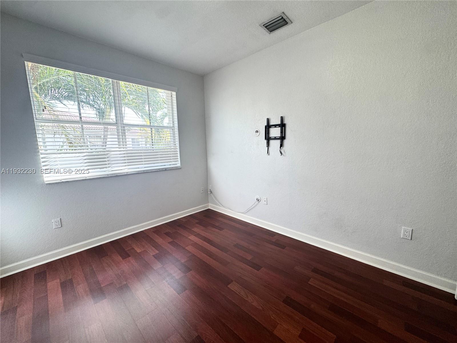 12283 Southwest 123rd Terrace Miami, FL 33186 - Photo 19 of 46 an empty room with wooden floor and windows