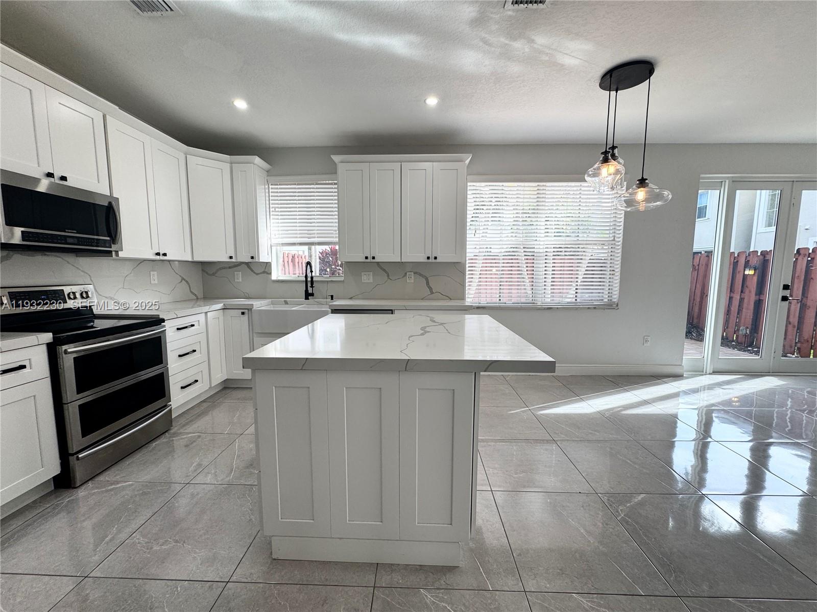 12283 Southwest 123rd Terrace Miami, FL 33186 - Photo 30 of 46 a kitchen with a sink a counter top space cabinets and stainless steel appliances