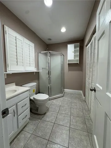 a bathroom with a granite countertop sink a toilet and a shower