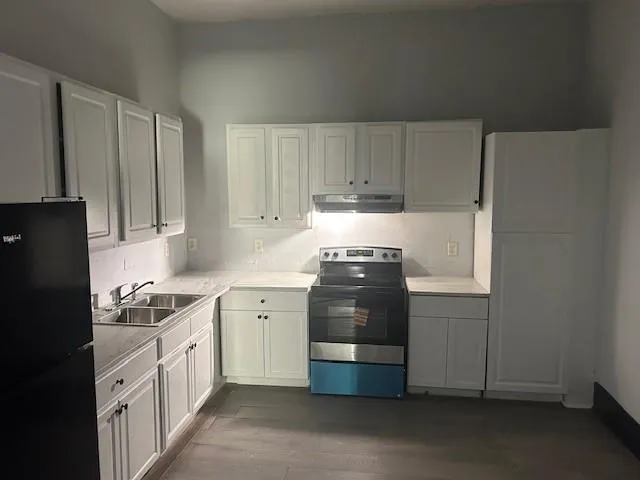 a kitchen with stainless steel appliances a stove a refrigerator a sink and cabinets