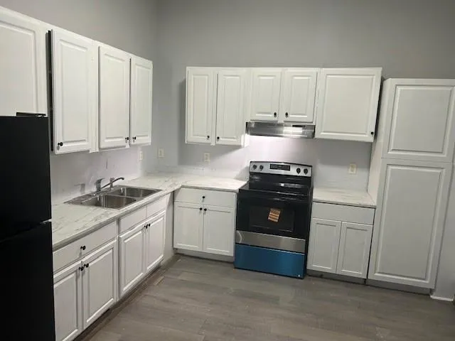 a kitchen with granite countertop white cabinets and stainless steel appliances