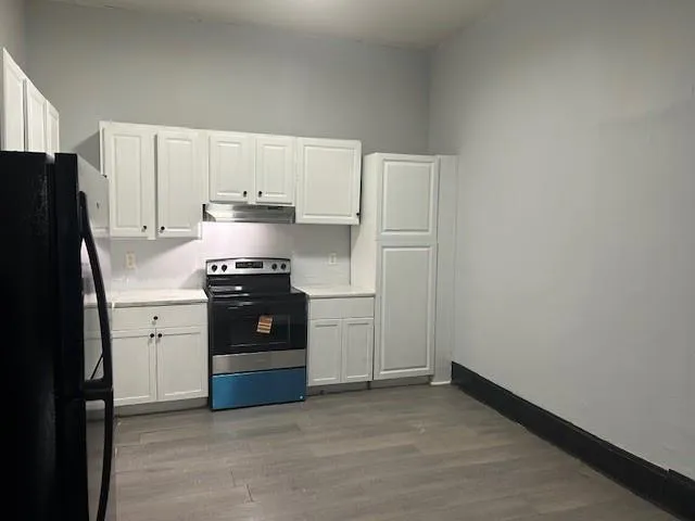 a kitchen with a refrigerator stove and white cabinets
