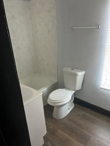 a white toilet sitting next to a bath tub