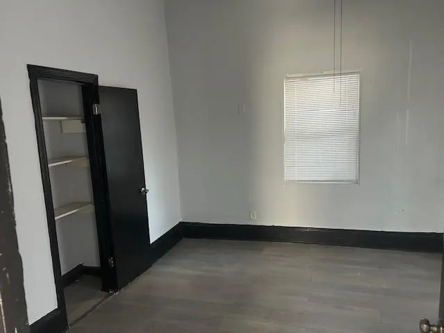 an empty room with wooden floor and a window