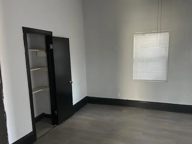 an empty room with windows and closet